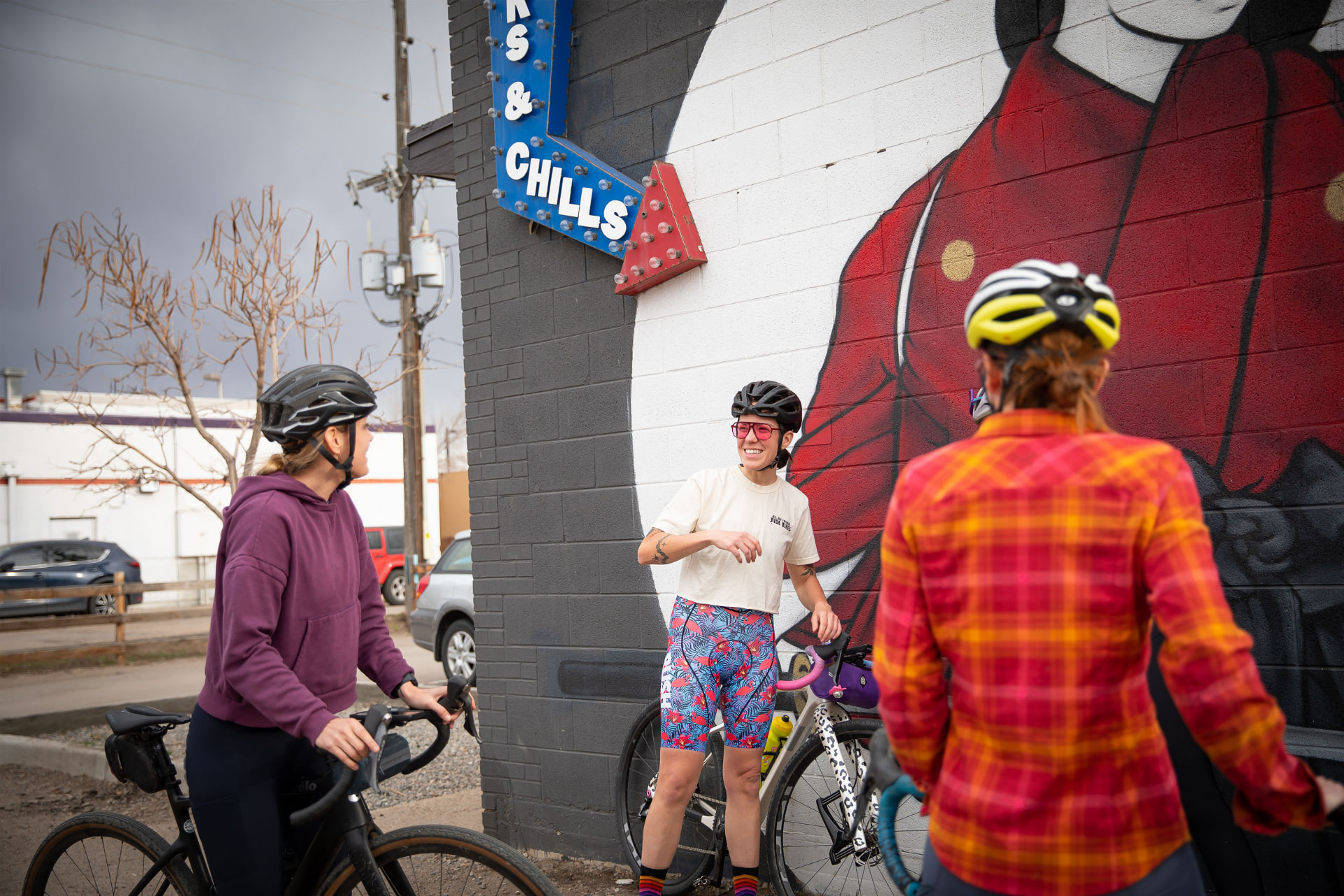 TGIF riders stopping together beside a mural