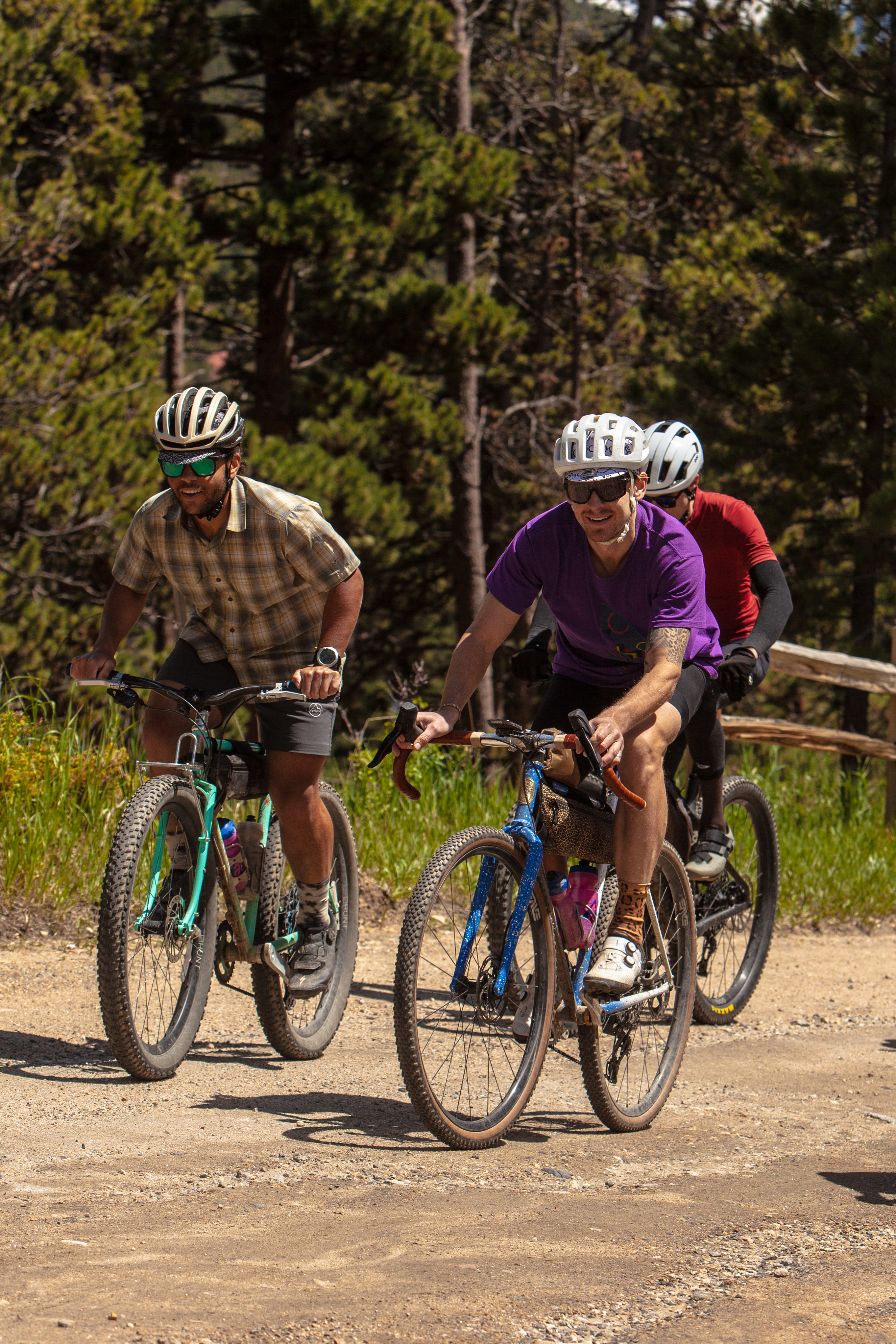TGIF riders rolling together along a wooded gravel road