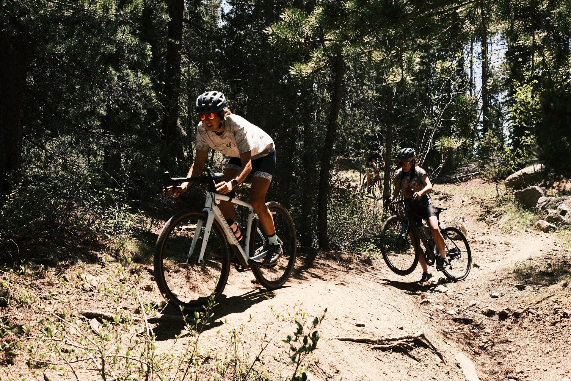 Far Out riders climbing through the pines